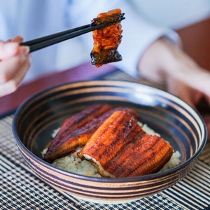 うなぎの蒲焼を食べる人