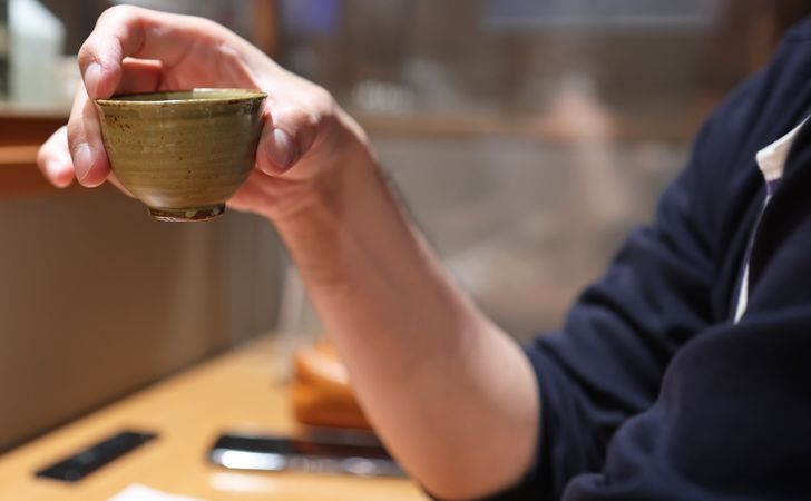 お猪口でお酒を飲む人